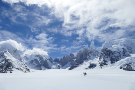 two persons standing near mountain during winter season in El Chaltén Argentina