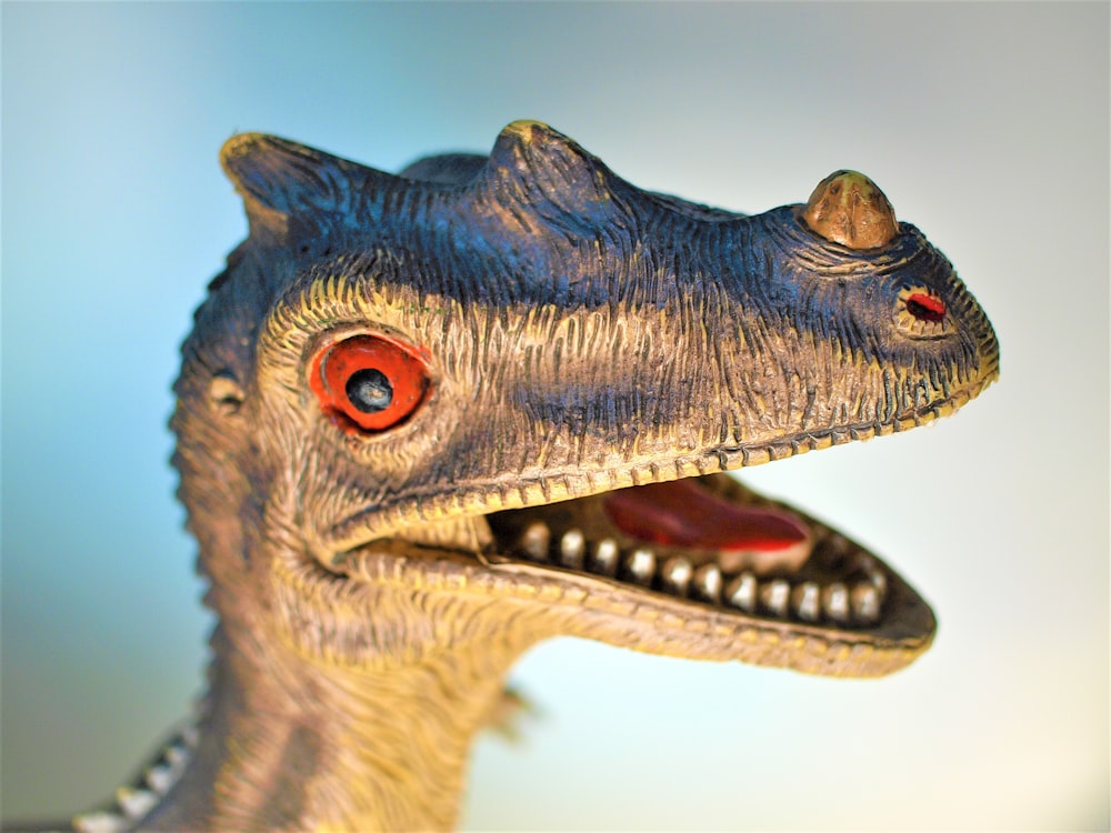 closed-up photo of gray dinosaur figurine