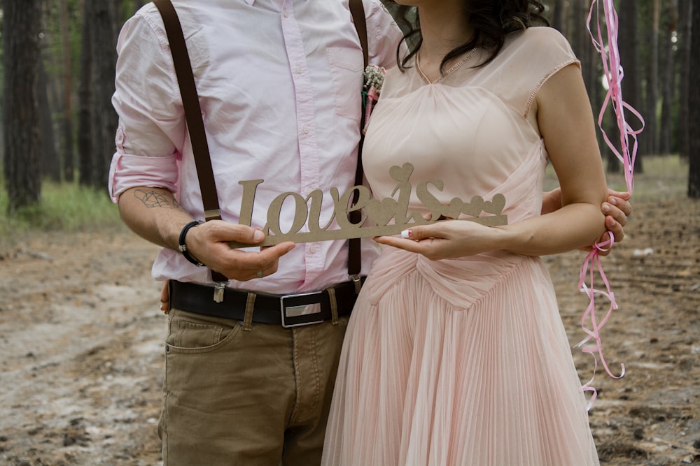 man and woman hugging each other and holding love decor