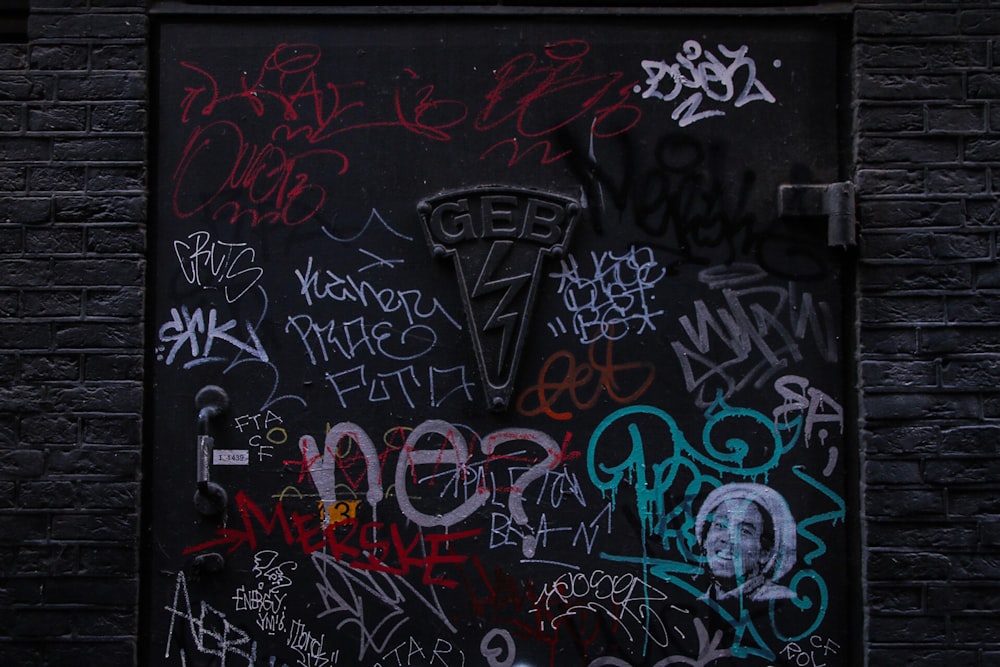 Schwarze Metalltür mit Graffiti