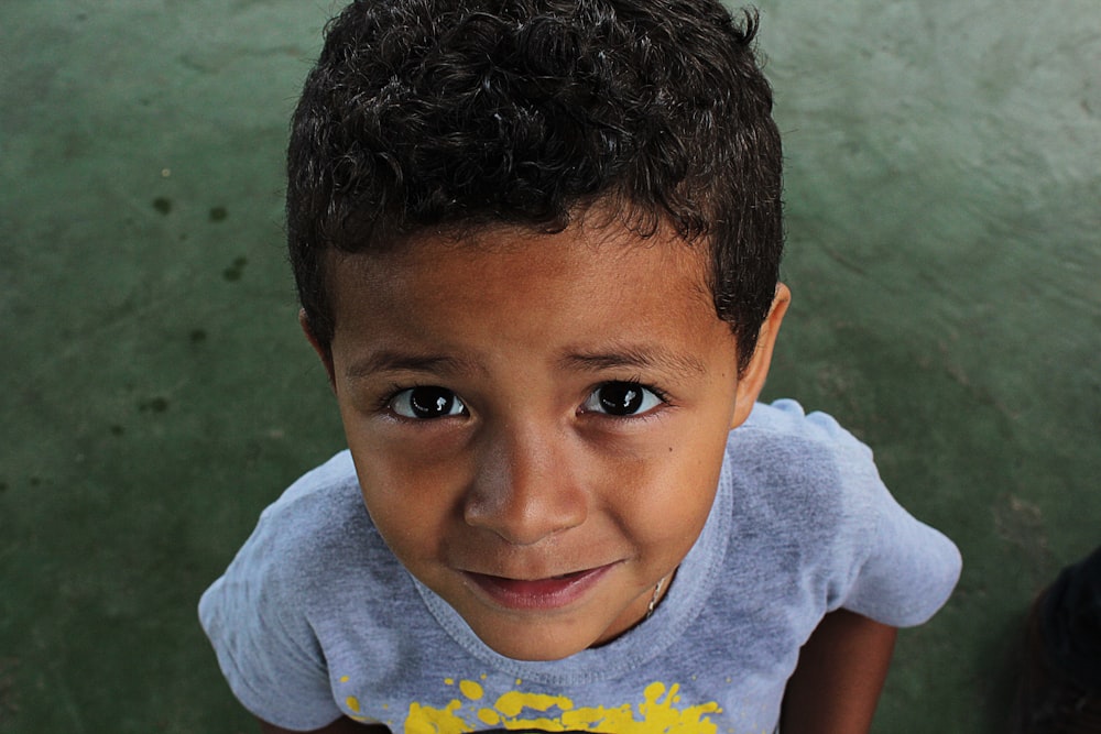 boy wearing gray crew-neck t-shirt looking up