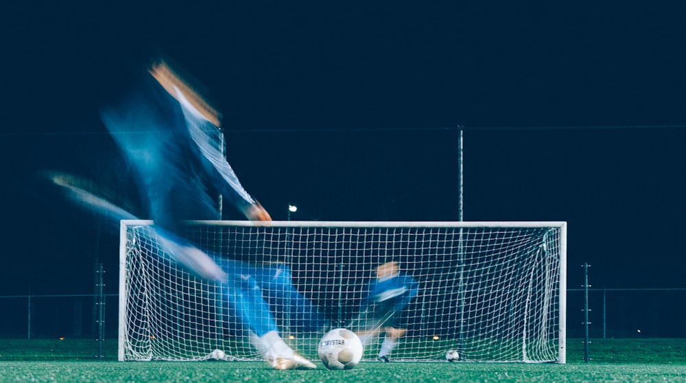 timelapse photo of soccer player kicking ball