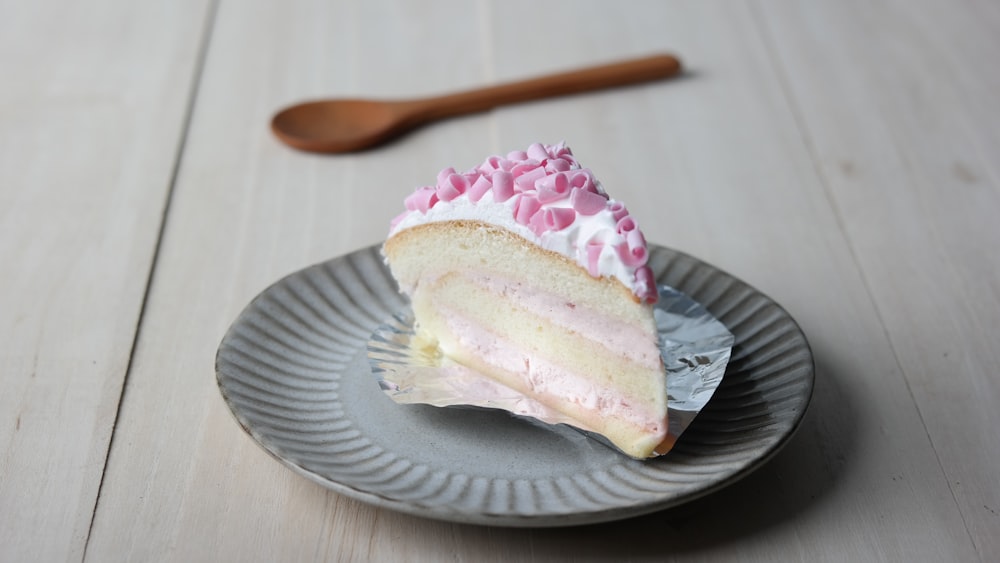 Tarta de gasa con glaseado blanco y chocolate rosa rallado en plato gris