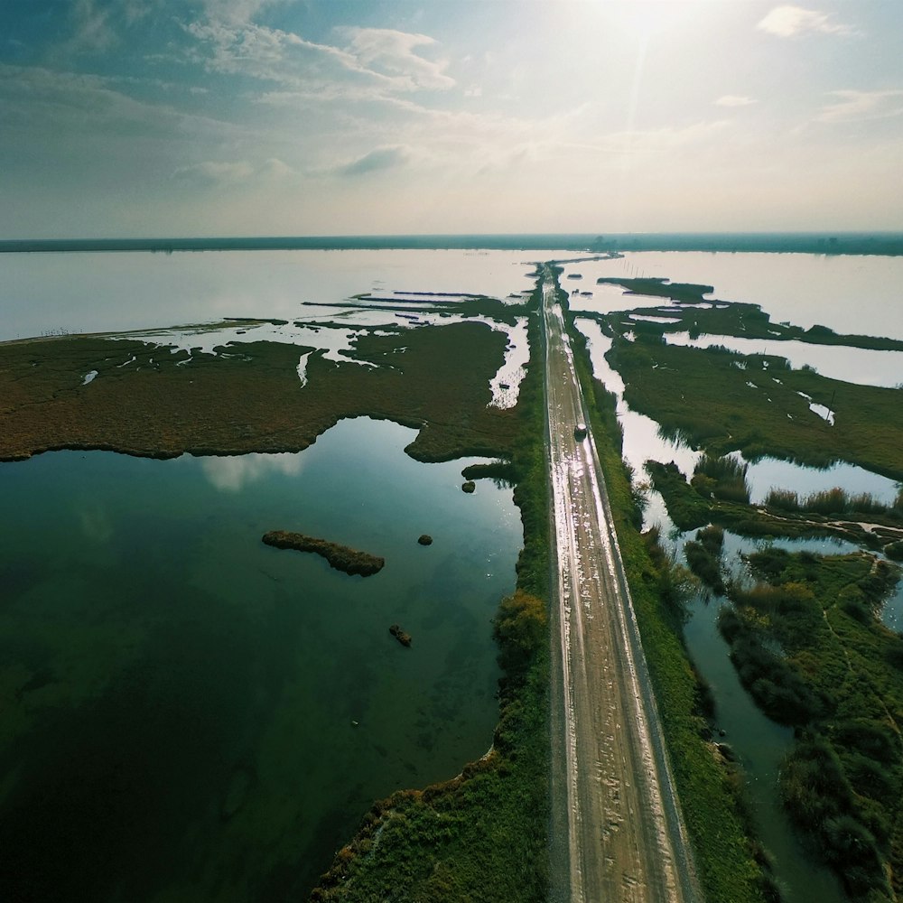 Fotografía aérea de una carretera asfaltada entre un cuerpo de agua