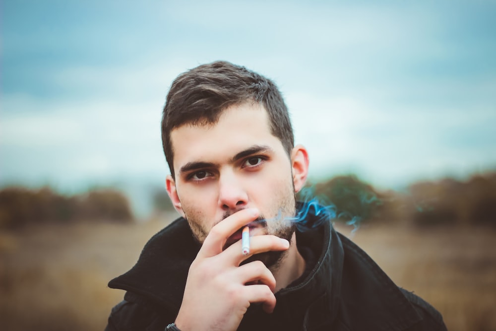 man smoking cigarette taken at daytime