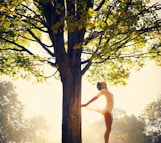 woman dancing under green tree during daytime