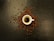 Artful shot of a dark coffee cup with crema, surrounded by coffee beans and a small pot.