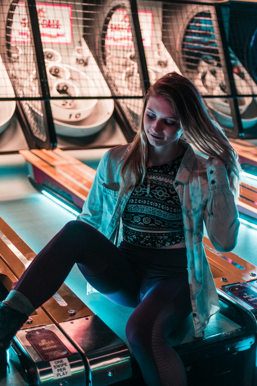 woman sitting on arcade machine