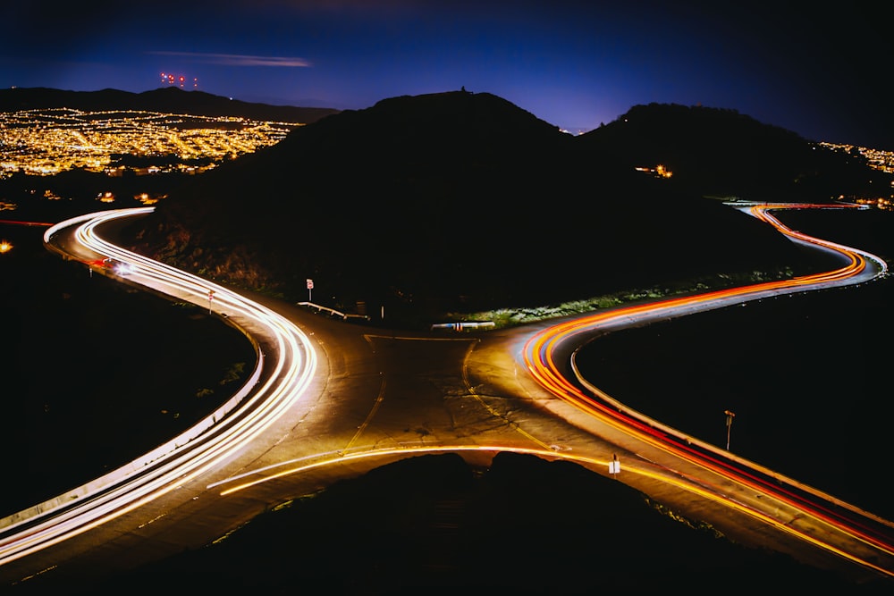 aerial view photography of cross road near mountain during nighttime