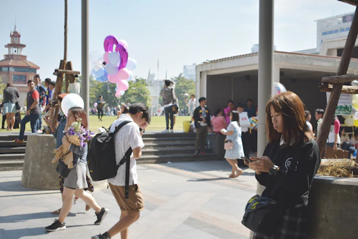A lively neighborhood gathering with smiling people enjoying outdoor activities on a sunny day.