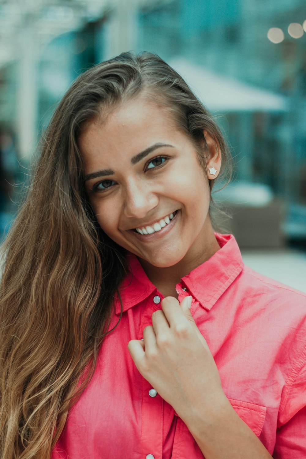 Selektive Fokusfotografie einer Frau, die ein rotes Oberteil mit geknöpftem Kragen trägt und lächelt