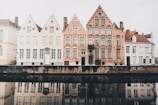 buildings near body of water under white clouds at daytime