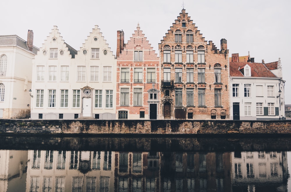 buildings near body of water under white clouds at daytime