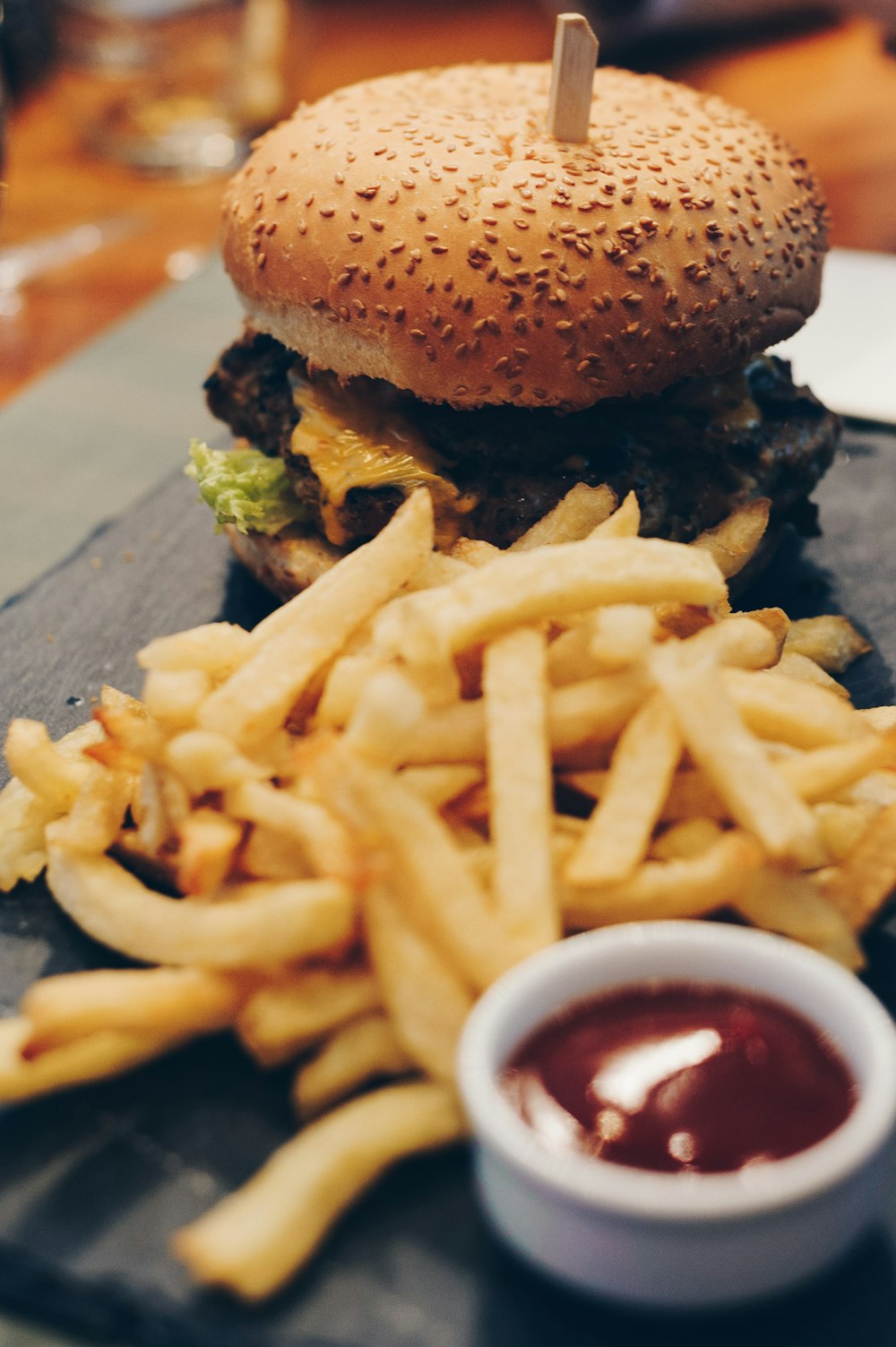 burger with fries on brown wooden plank
