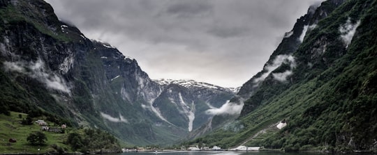 green and black mountain under the gray cloud at daytime in Gudvangen Norway