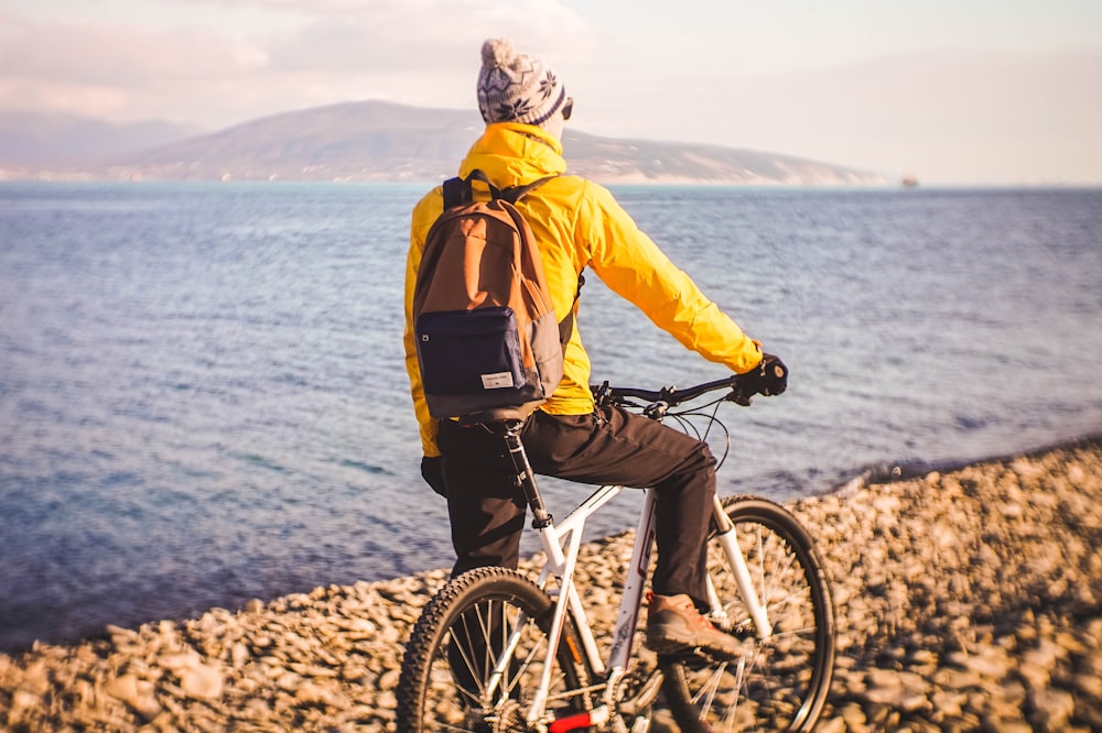 man riding bike near body of water