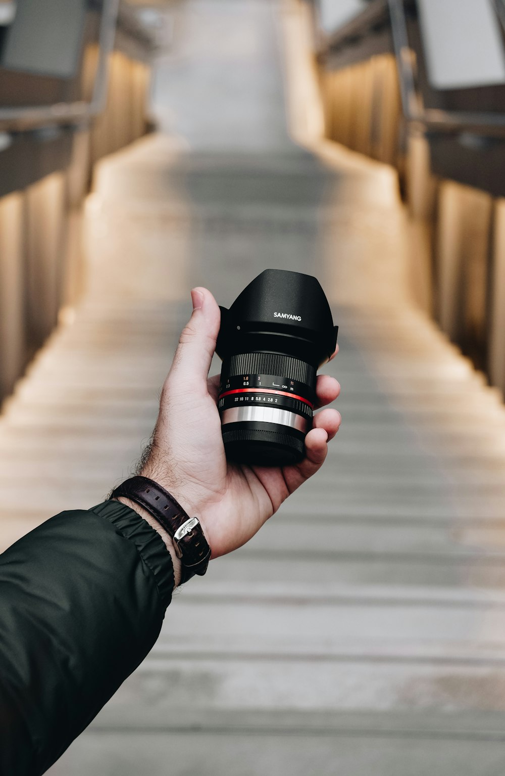 person holding DSLR camera lens