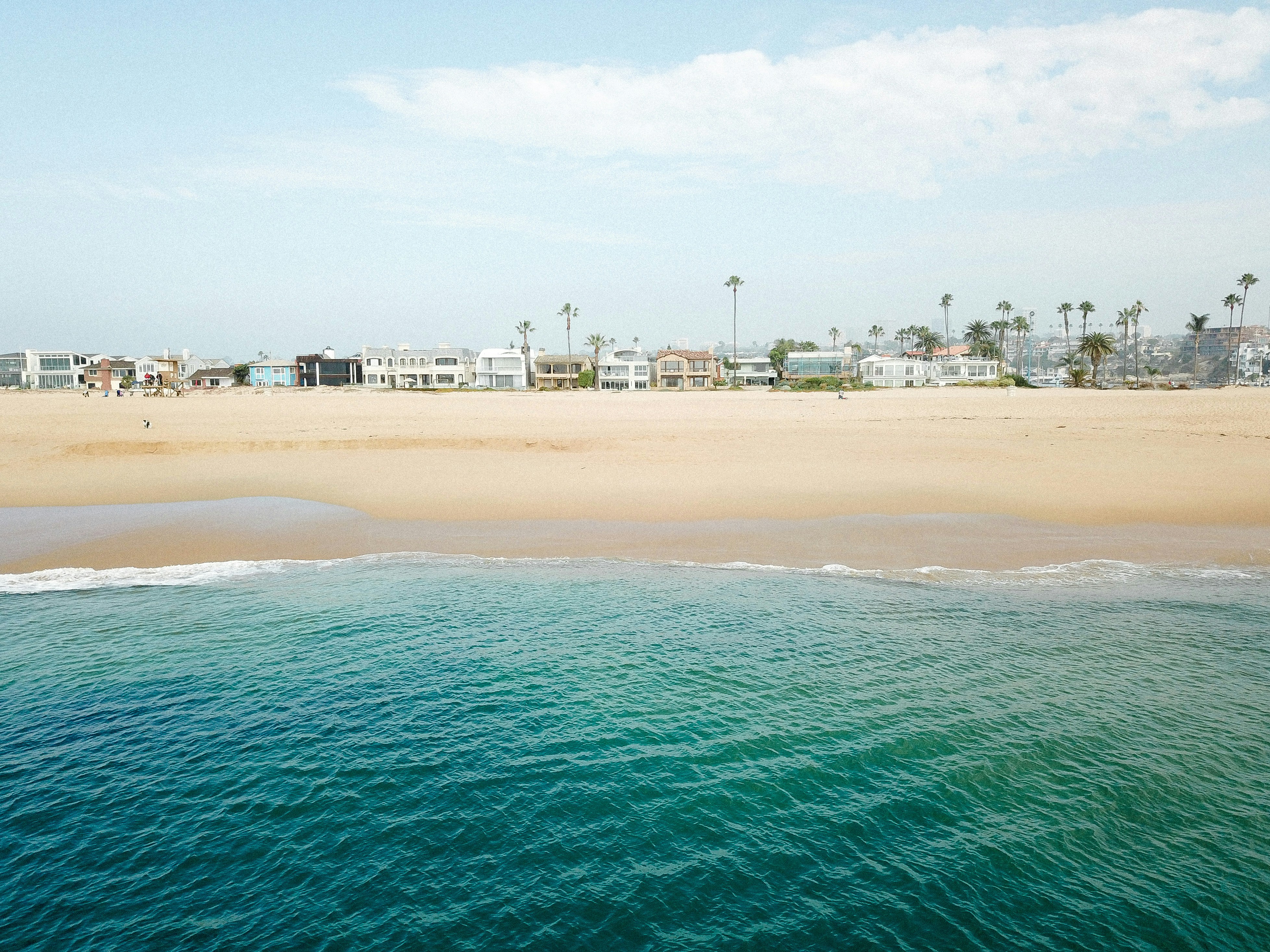 buildings near white sand beach under blue skies, Newport Coast