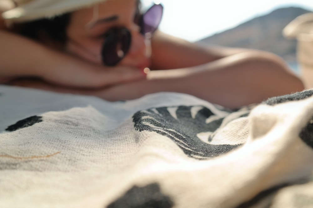 woman lying on white and black textile during daytime