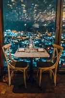 A beautifully set table at a rooftop dinner overlooking the Burj Khalifa lit up at night.