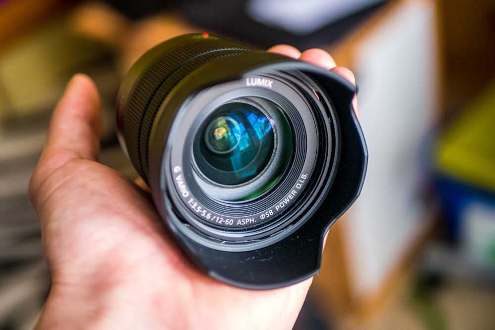 selective focus of person holding Lumix camera lens