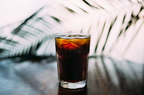 selective focus photo of glass of brown liquid