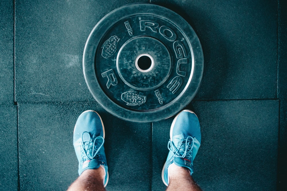 person standing beside black weights