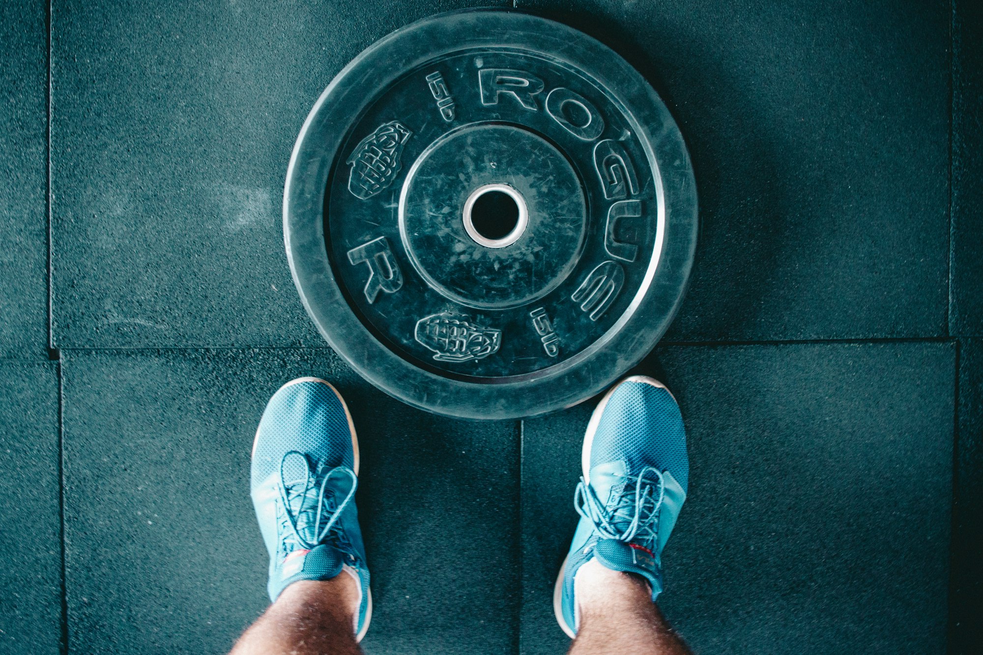 person standing beside black weights