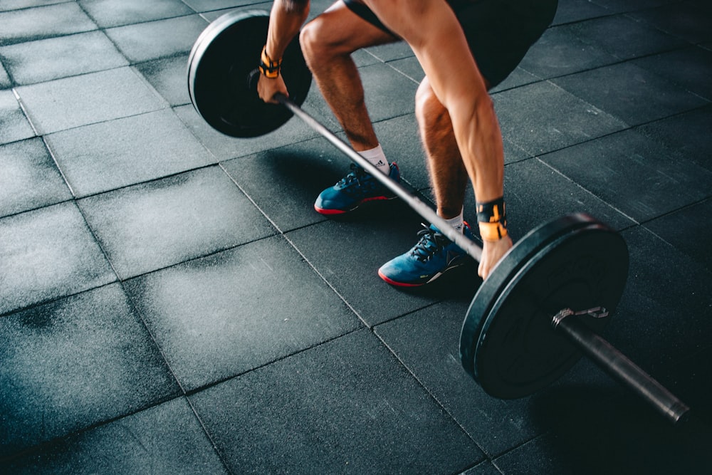 person holding black barbell