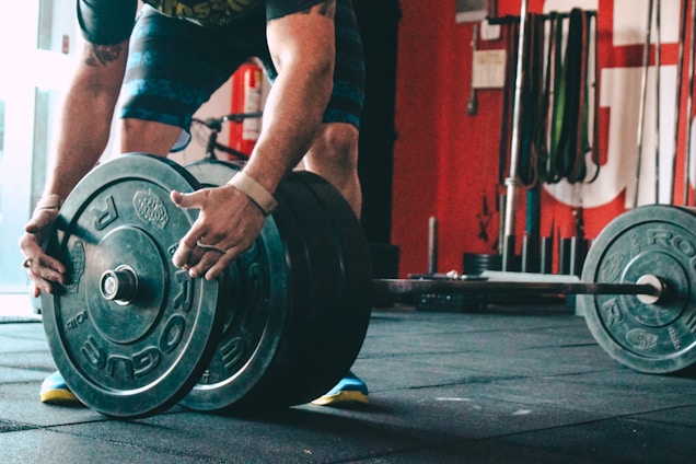 man placing weight plate on barbell