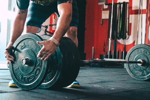 man placing weight plate on barbell