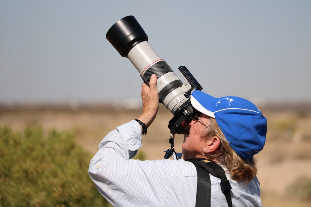 person holding DSLR camera taking a picture during daytime