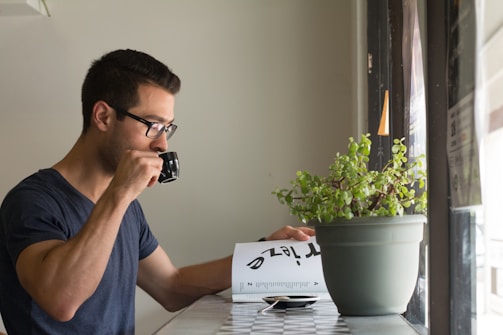 A calm morning scene with a planner, glasses, and a cup of tea by the window.