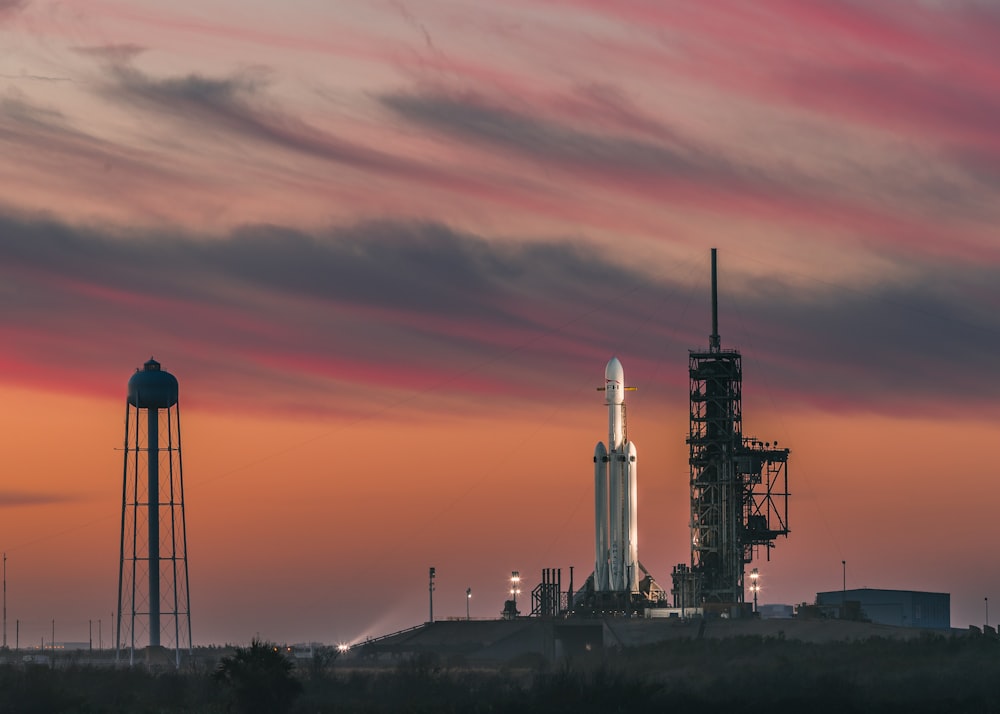 white rocket under nimbus clouds at golden hour