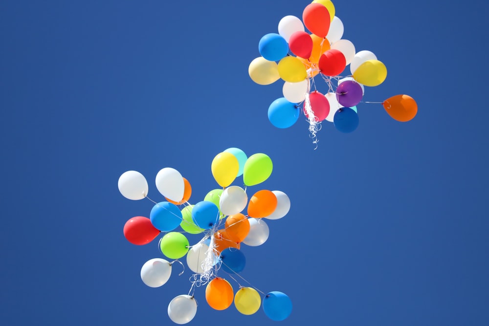 Balões de cores variadas voando no céu durante o dia