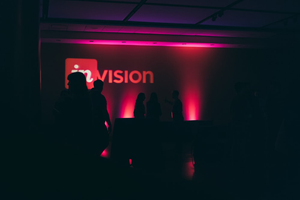 a group of people standing in front of a vision sign