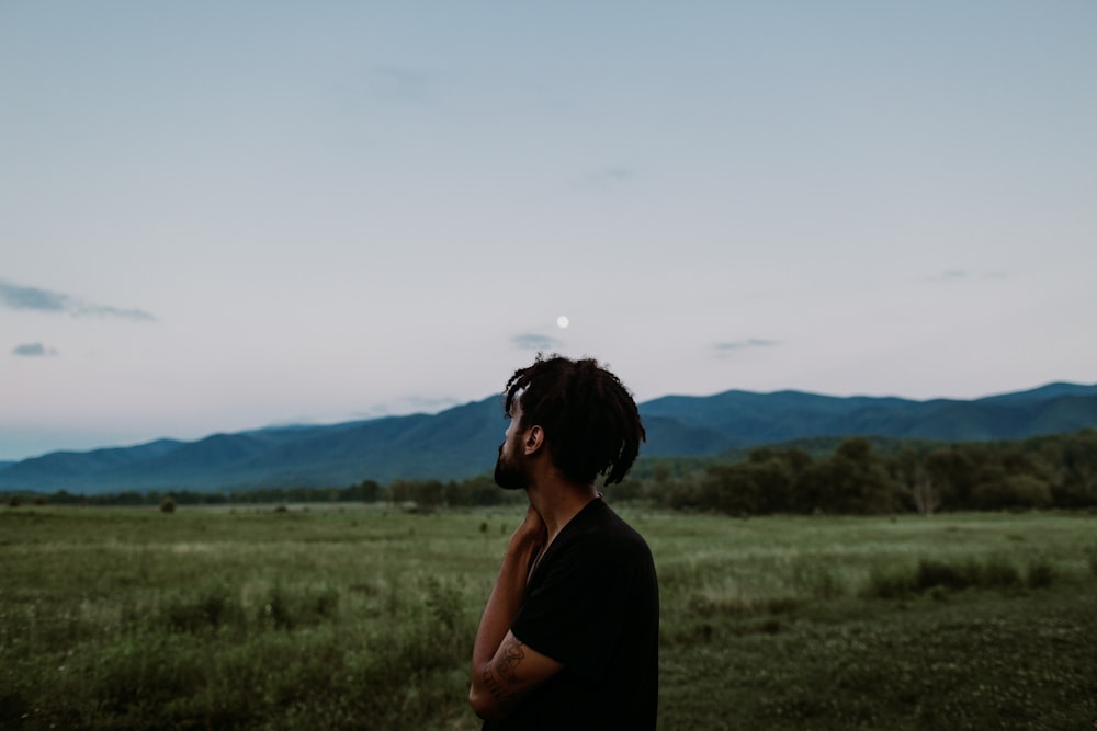 man standing on green grass field