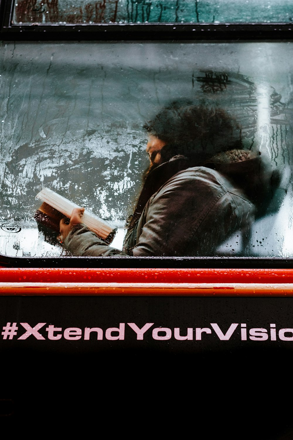 a man reading a book while sitting in a bus