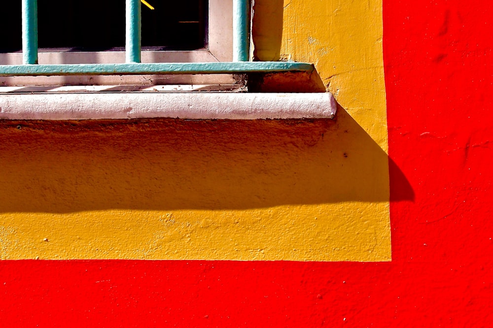 a red and yellow building with a window