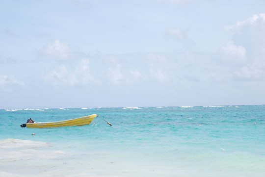 yellow boat on body of water photo in Punta Cana Dominican Republic