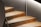 Close-up of a beautifully renovated staircase with a warm wood finish.