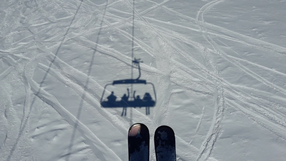 Photographie aérienne de l’ombre des remontées mécaniques sur le champ de neige pendant la journée
