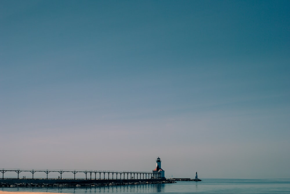 white and brown lighthouse tower under blue skies