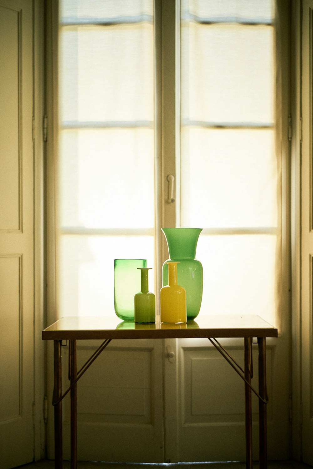 Foto de jarrones encima de la mesa frente a la ventana