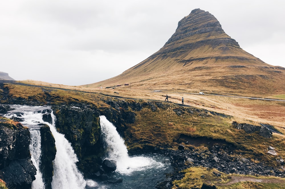 brown mountain beside waterfall