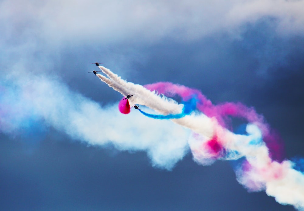 um jato colorido voando através de um céu azul nublado
