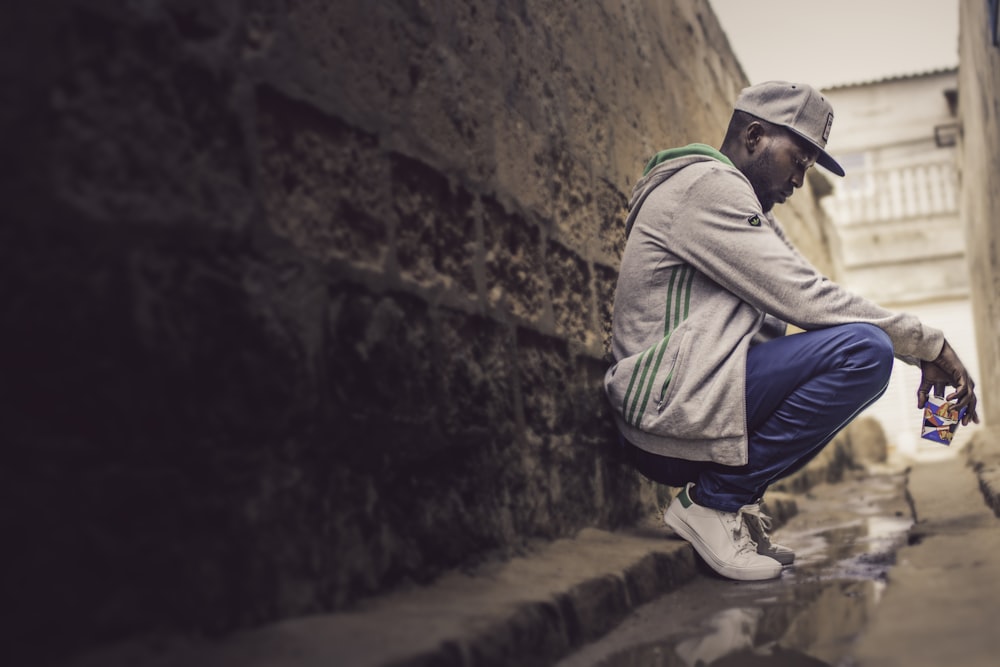 man sitting against wall