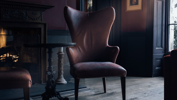 brown fabric seat near brown wooden pedestal table