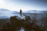 A lone explorer standing on a snowy ridge overlooking vast frozen wilderness