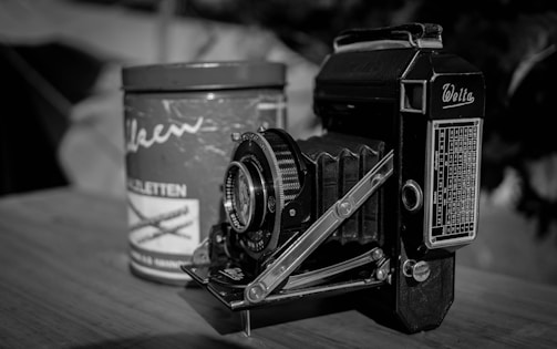 Vintage stereoscopic camera from late 19th century displayed on wooden table.